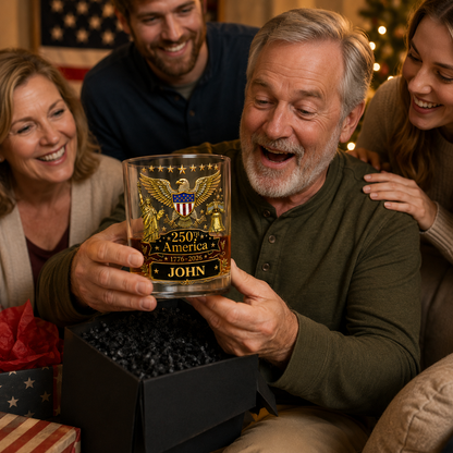 Man receiving a personalized whiskey glass from friends during a celebration.